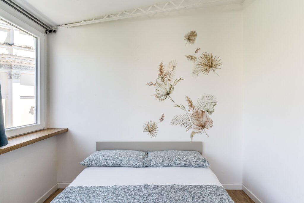 Camera doppia con pareti chiare e decoro floreale – casa vacanze The Trident Retreat